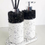 Conjunto de itens de banheiro com dispenser e difusor em um design moderno, com detalhes em preto e base branca.