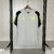 Camisa de treino cinza do Flamengo, versão torcedor, com detalhes em amarelo e preto, pendurada em um cabide.