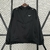Corta-vento Nike masculino na cor preta, com zíper e capuz, exibindo o logo da marca na parte frontal.