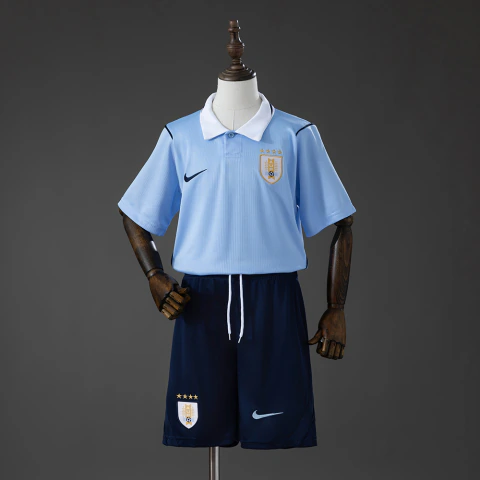 Este é o conjunto infantil titular da Seleção do Uruguai para a Copa do Mundo de 2026 da Nike, que se destaca pela clássica camisa azul-celeste com gola polo branca combinada com shorts azul-marinho