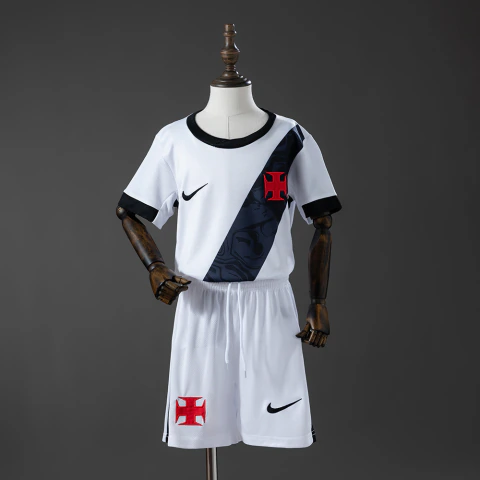 Este é um conjunto infantil do Vasco da Gama da temporada 2026/2027, destacando a camisa branca com a faixa diagonal preta e o logo da Nike