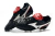 Black and red soccer cleats with white detailing, featuring a textured upper and a padded collar.