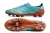 Mizuno soccer cleats in turquoise with a brown sole, showcasing a sleek design and textured upper.