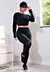 Modelo vestindo conjunto cropped e calça legging preta com detalhes em tela, posando em ambiente interno.