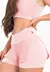 Short saia corrida liso na cor rosê, destacando seu design moderno e confortável, ideal para atividades de moda fitness.