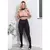 Modelo usando conjunto fitness com calça legging preta e cropped rosa, posando em ambiente interno.