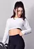 Top cropped manga longa de tela Dry Fit branca, modelo feminino em pose de treino com halteres.
