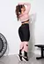 Modelo vestindo conjunto fitness rosa e preto, com calça legging e top cropped, em ambiente de academia.