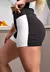 Short fitness preto com detalhes brancos, ideal para academia, com cintura alta e ajuste confortável.