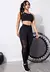 Modelo vestindo conjunto fitness feminino de legging e top com transparência, em fundo claro.