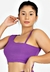 Modelo usando um conjunto cropped roxo com detalhe nas costas, destacando o estilo fitness.