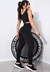 Modelo vestindo conjunto de calça legging e cropped preto, posando em frente a um trampolim.