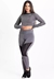 Conjunto fitness composto por calça legging cinza com tela e cropped de manga longa na mesma cor.
