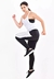 Mulher usando um conjunto fitness com calça legging, regata de tela e top tomara que caia, em pose dinâmica.