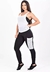 Conjunto fitness com calça legging preta, regata de tela branca e top tomara que caia, exibindo detalhes em tela.