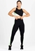Conjunto de moda fitness composto por cropped preto com detalhes em verde e calça legging preta com detalhes em verde, modelagem ajustada.
