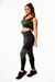 Modelo usando um conjunto de calça legging preta com detalhes em verde militar e cropped regata com detalhes em tela, ideal para academia.