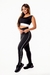 Conjunto fitness feminino com calça legging preta e cropped regata, detalhes em branco, ideal para academia.