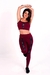 Mulher sorridente usando um conjunto fitness marsala, composto por calça legging de cintura alta e cropped, com detalhes em elástico e estampas.