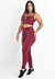 Modelo usando conjunto fitness composto por calça legging de cintura alta e cropped marsala, com detalhes em elástico.