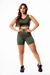 Conjunto fitness feminino composto por cropped e short de cintura alta na cor verde militar, modelo em pé com expressão confiante.