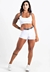 Conjunto fitness branco composto por cropped e short, apresentado por uma modelo com cabelo longo e tatuagens.
