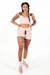 Conjunto fitness rosa com cropped de alça dupla e short cintura alta, modelo posando em pé.