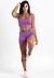Modelo usando um conjunto fitness roxo, composto por cropped e short, destacando o design moderno e confortável.