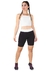 Mulher usando um conjunto fitness com cropped branco e shorts preto com detalhes brancos, posando em pé.