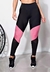 Calça legging cintura alta assimétrica em preto com detalhes em rosa e tela, ideal para moda fitness.