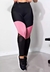Calça legging cintura alta assimétrica com detalhes em rosa e tela preta, ideal para moda fitness.