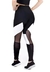 Calça legging cintura alta assimétrica em preto com detalhes em branco e tule, vista traseira.