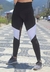 Calça legging cintura alta assimétrica em preto e branco, com detalhe em tulê e tela, em ambiente ao ar livre.