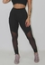 Calça legging fitness preta com detalhe em tule, vista frontal de uma modelo.
