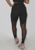 Calça legging fitness preta com detalhe em tule, vista traseira, usada por uma modelo