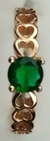 Anillo de corazones con piedra verde esmeralda.