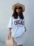 Modelo usando uma T-Shirt off white, oversize, com estampa chicago.