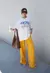 Modelo usando uma T-Shirt off white, oversize, com estampa peaches.