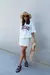 Modelo usando uma T-Shirt off white, oversize, com estampa chicago.