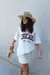 Modelo usando uma T-Shirt off white, oversize, com estampa chicago.