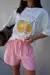 Modelo usando uma T-Shirt off white, oversize, com estampa orange.
