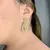 Brinco oval cravejado de pedras azuis banhado a Ouro 18K na internet
