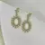 Brinco oval cravejado de pedras azuis banhado a Ouro 18K