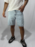 Bermuda jean mom en color celeste, modelo con corte relajado, combinado con una camiseta blanca y zapatillas negras.