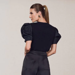  T-shirt Nélia une o básico ao sofisticado em uma proposta contemporânea e impactante. Em malha viscolaicra na cor preta — composta por viscose com elastano — essa peça oferece um toque macio, caimento leve e extremo conforto. A elasticidade da malha conf