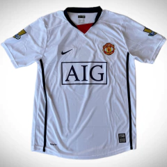 Camiseta blanca del Manchester United, modelo suplente de la temporada Premier League 2009, con el logo de Nike y la insignia del club en el pecho.