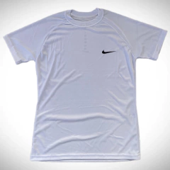 Remera deportiva blanca de Nike con logo negro en el pecho.