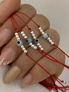 Pulsera de hilo con ojo turco celeste y bolitas
