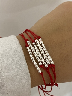 Pulsera de hilo y bolitas de plata en internet