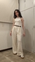 Modelo luciendo un top halter blanco con pantalones claros en un ambiente interior.